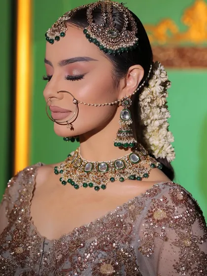 A side profile showcasing the elegance of our bridal jewellery. The matha patti, nath, and jhumka earring come together to create a flawless traditional look.