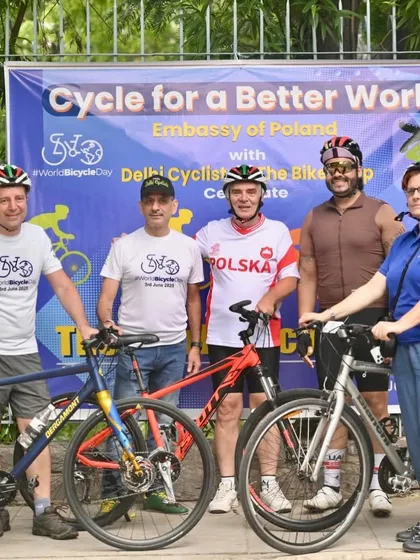 Posing with the official banner for the "Cycle for a Better World" event.