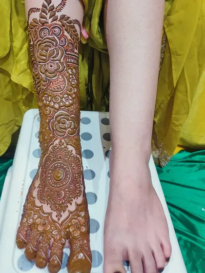The process of creating a bridal foot design, showing one leg complete and the other ready for its art.