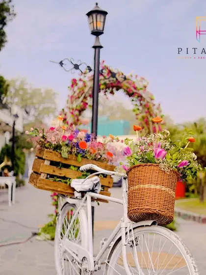 We love incorporating whimsical elements. This vintage white bicycle with baskets overflowing with colorful flowers served as a charming and unique decor piece for an outdoor event.