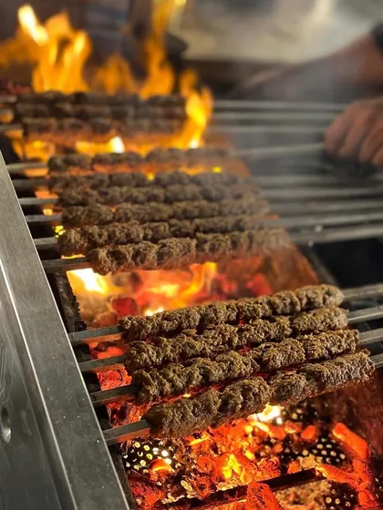 Rows of succulent Mutton Seekh Kebabs sizzling over a fiery charcoal grill, a classic and beloved offering at my barbecue station.