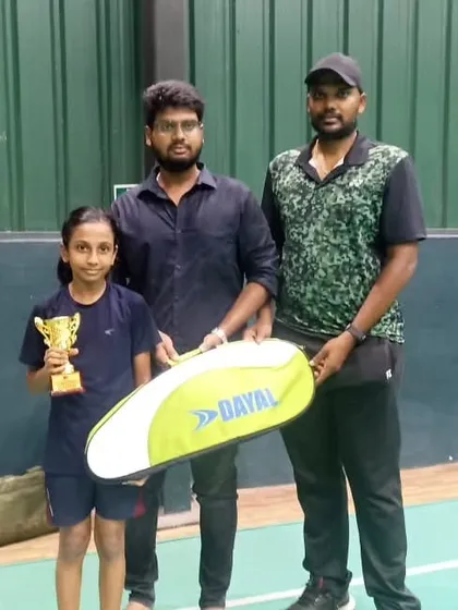 Our student Niralya from Fame Badminton Academy with her coach and trophy after a win in the U-11 girls singles category.