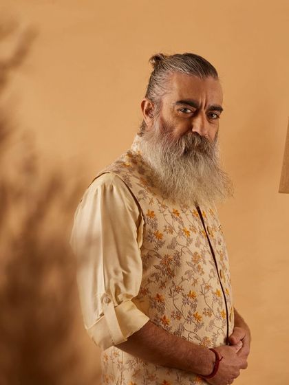 This floral printed vest in neutral tones offers a sophisticated yet relaxed look. It's a versatile piece that can be dressed up or down for any semi-formal occasion.