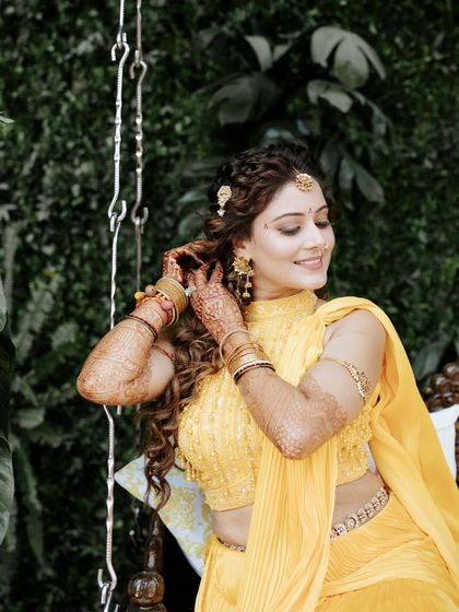 A close-up of the bride's detailed Haldi look, from her floral-inspired hairstyle to her delicate jewellery.
