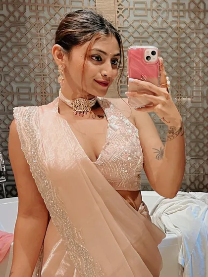 A mirror selfie capturing the full effect of this modern saree look. The halter-neck design and delicate fabric make it a standout choice for any wedding event.