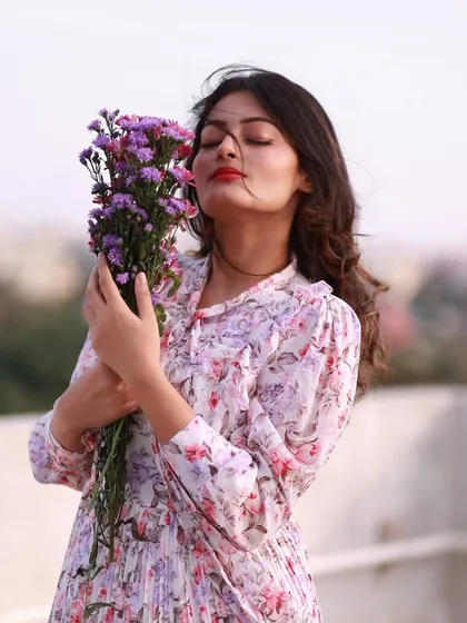 A moment of pure serenity. With eyes closed, she breathes in the scent of the flowers, creating a portrait of peace and mindfulness.