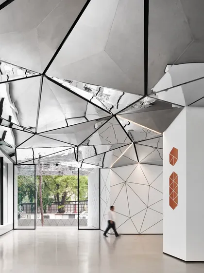 The view from the entrance showcases the seamless fusion of architecture and art. The reflective ceiling draws the outside in, while the geometric patterns create a continuous visual narrative.