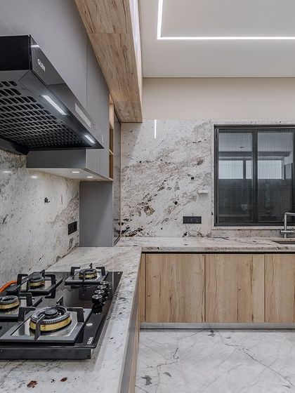 The cooktop area is framed by the stunning Brazilian granite, which extends from the counter up to the backsplash for a seamless and high-impact look.