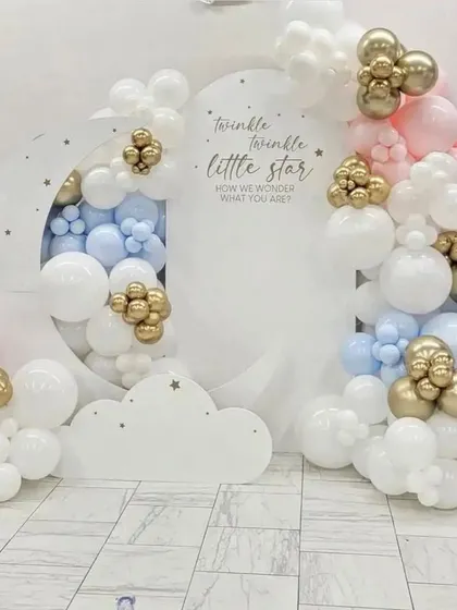 A dreamy "Twinkle Twinkle Little Star" theme, perfect for a gender-neutral baby shower or first birthday. The design uses a large crescent moon cutout backdrop, surrounded by soft clouds of pink, blue, and white balloons with pops of metallic gold. It’s a classic theme that I love to create.