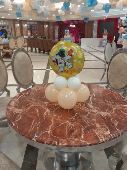 An astronaut-themed foil balloon centerpiece, perfect for adding a fun touch to the tables at a space-themed birthday party.