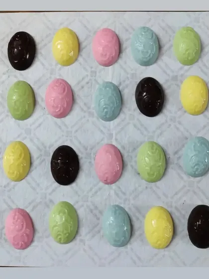 An assortment of my molded chocolate Easter eggs in various pastel colors and dark chocolate. They are perfect for Easter baskets or as a small, sweet gift.