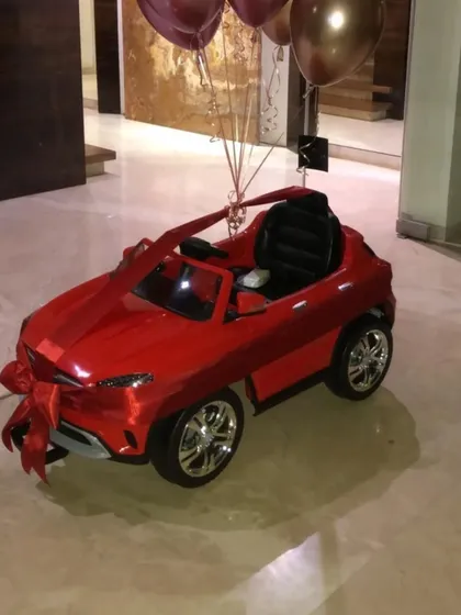 A fun way to present a big gift. We decorated this toy car with a red ribbon and balloons for a child's birthday surprise.