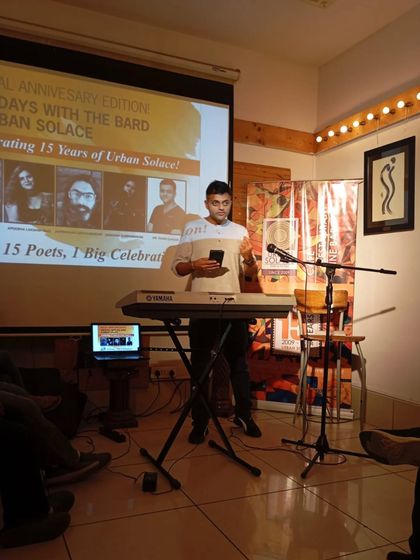 A performer uses a keyboard to add a musical layer to his poetry. We encourage artists to experiment and combine different art forms on our stage.