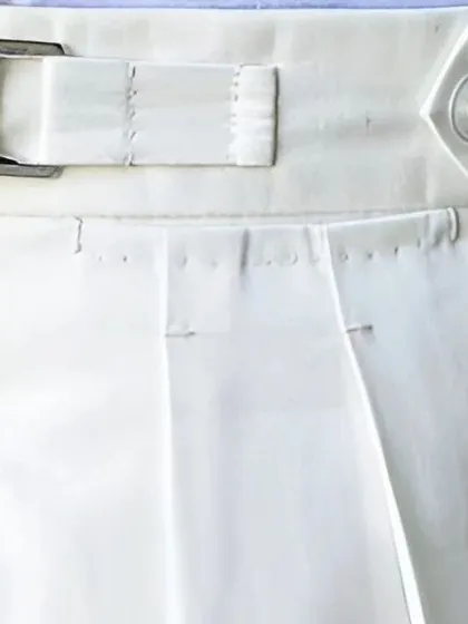 A detailed view of the waistband on our white trousers, showing the precise stitching and construction of the side adjuster.