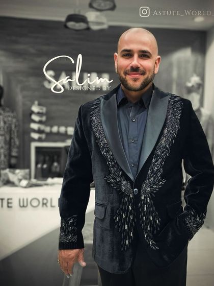 A client in a black velvet blazer with silver embroidered feather motifs on the lapels. It's an elegant and artistic design that's both subtle and striking.