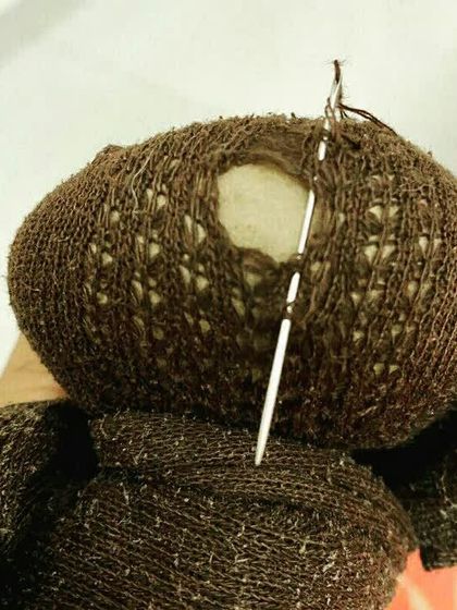 A close up of a sock being darned. This traditional mending technique is a simple, effective way to extend the life of clothing and reduce waste, one sock at a time.