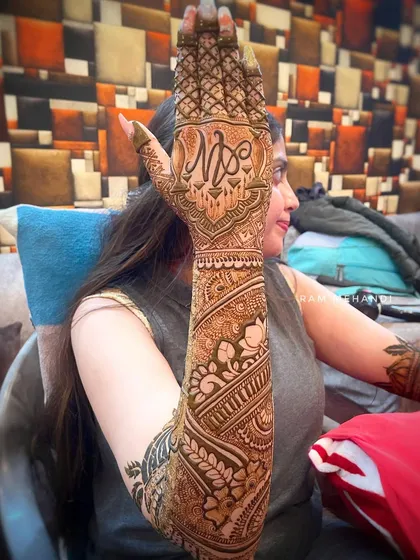 A full-arm bridal design shown from the side. This view highlights the seamless flow of patterns from the wrist to the elbow, featuring a custom initial monogram on the back of the hand.