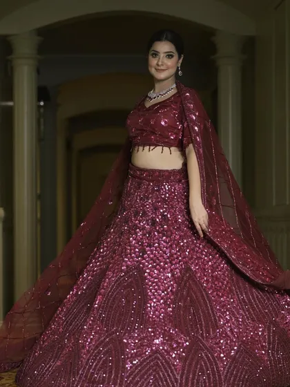 A beautiful portrait in our wine-colored sequin lehenga. The simple silhouette allows the rich color and sparkling texture to take center stage.