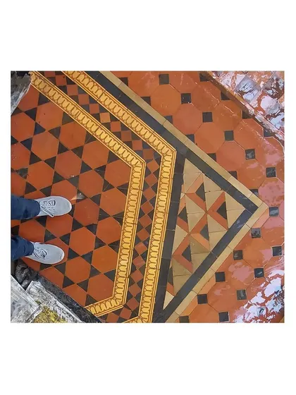 The bold geometry of this terracotta and black tile pattern creates a powerful visual statement. Our restoration process involved carefully cleaning and sealing these floors to bring back their original vibrancy.