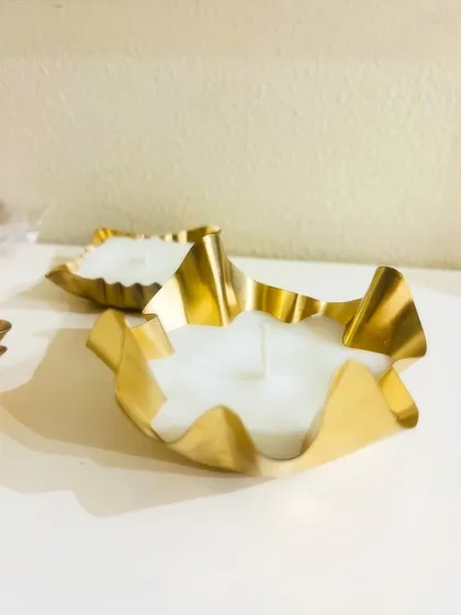 A side view of our crinkled gold urli candles. The unique texture adds a touch of modern artistry to your festive decorations.