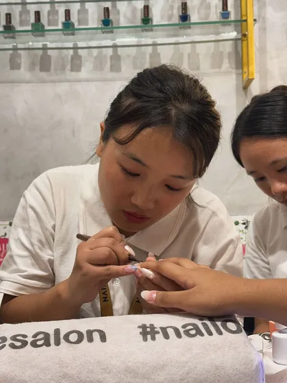 One of our talented nail artists concentrating on creating a beautiful set of extensions. Perfection can't be rushed, and our team takes the time to get it right.