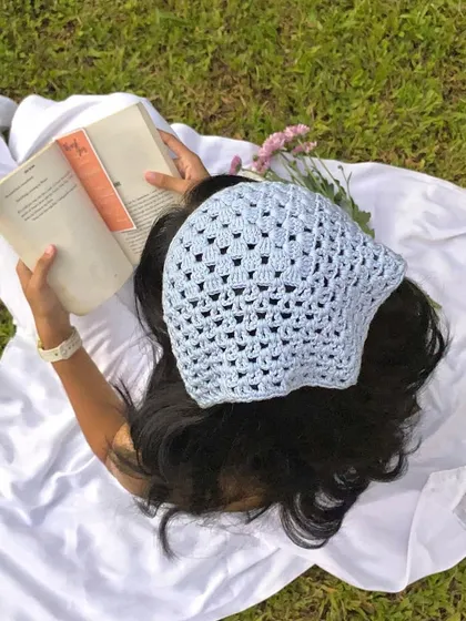 A dreamy picnic scene featuring our handmade blue crochet bandana. It's the perfect accessory for a soft girl or cottagecore look.