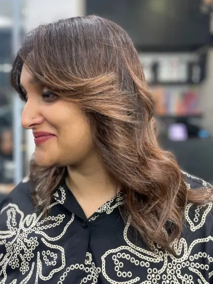 A classic layered cut with a gentle wave, giving the hair body and movement. This is a timeless look that never goes out of style.