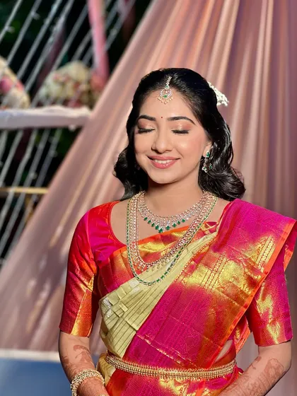 The makeup for this look features soft, shimmery eyeshadow and a natural lip color, creating a dreamy and romantic feel that complements her beautiful saree.