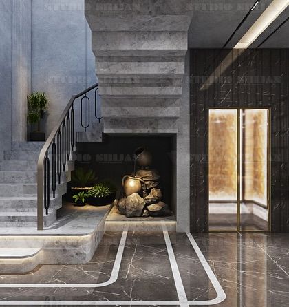A unique feature of this entertainment hall is the serene water feature and statue placed under the staircase, adding a touch of tranquility.