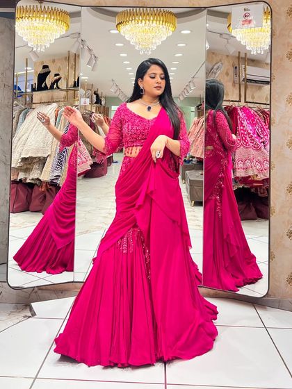 A full view of a stunning magenta indo-western lehenga with a pre-draped dupatta. This modern silhouette is perfect for a cocktail or sangeet.