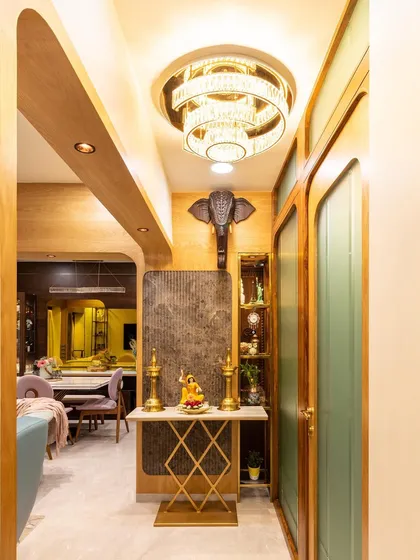 This transitional foyer design uses clean lines and a stunning crystal chandelier to create a warm and welcoming ambiance. The elephant head sculpture adds a touch of traditional grandeur.