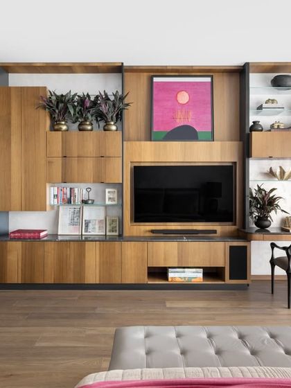 A key feature of the master bedroom is this seamless custom wall unit we designed. It integrates bookshelves, a media center, a work desk, and storage into one cohesive piece, anchored by a vibrant Gopi Gajwani canvas, making the space highly functional without sacrificing beauty.