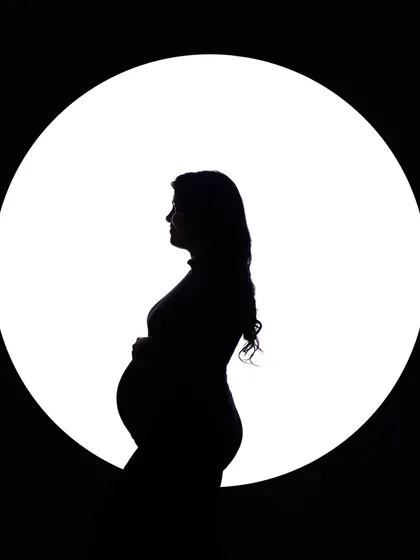 Sometimes, the most powerful stories are told in silhouette. This classic black and white portrait uses dramatic lighting to emphasize the beautiful curve of the baby bump, creating an iconic and artistic image that is both intimate and profound.