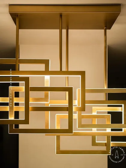 This modern architectural chandelier features an array of interlocking geometric squares with a brushed gold finish. The integrated LED lighting provides a warm, ambient glow, making it a sophisticated centerpiece for contemporary dining rooms and living spaces.