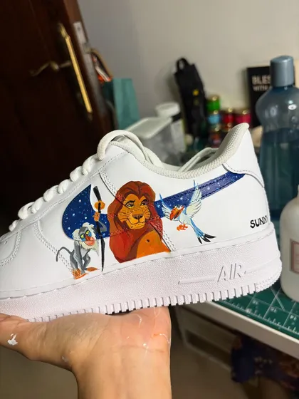 A classic Disney scene from The Lion King, hand-painted on the Nike swoosh of these custom Air Force 1s.