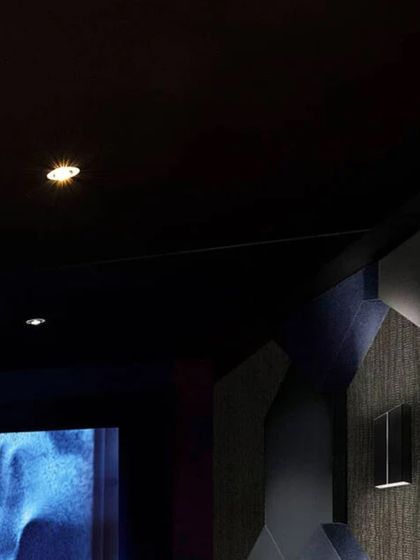 A closer look at the design elements of our "Entertainment Reimagined" concept. Notice the textured wall panels for acoustic treatment, the precise placement of recessed ceiling lights, and the comfortable, fabric-upholstered cinema seats.