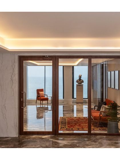 The lift lobby entrance to 'The Office with A View'. The combination of graphic marble flooring and large glass doors creates a sense of arrival and immediately draws the eye towards the sea view beyond.