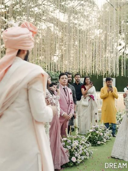 The bride's processional, with guests looking on. The aisle is designed to create a path of beauty, leading her to the start of her new journey.