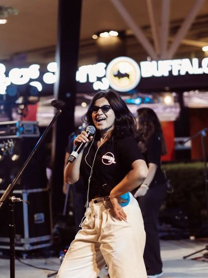 A happy, smiling shot of me on stage during an outdoor performance. This photo conveys the fun and engaging atmosphere of a Moksha All Stars gig.