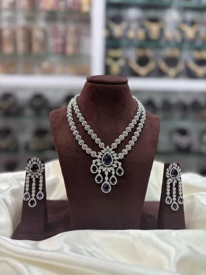 Another view of the layered AD necklace with a blue stone, shown in a shop setting.