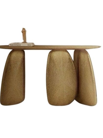 A truly sculptural console table. This piece features a slim wood top balanced on three irregularly shaped, textured gold legs, making it a functional work of art for any entryway.