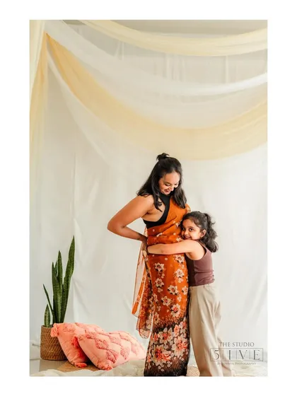 A warm studio portrait of a daughter giving her mother a heartfelt hug. Even with a simple backdrop, the love and connection between them is the focus of the image.