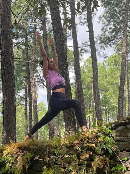 Another perspective of the Virabhadrasana I pose in the forest. This view highlights the upward reach of the arms, creating a line of energy from the earth to the sky.