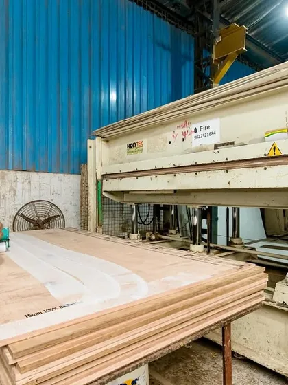 A skilled worker at our factory preparing plywood sheets. We use high-quality materials as the foundation for every kitchen we build, ensuring strength and longevity.