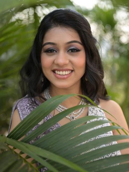 A fresh and youthful engagement look. The bride's lavender lehenga is paired with shimmery eye makeup and a bright, happy smile.