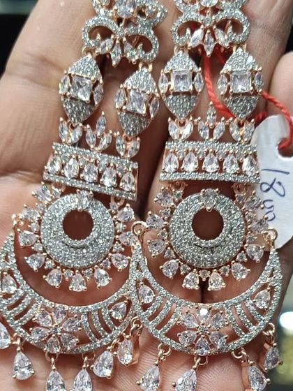 A pair of heavy American Diamond chandbali earrings with a rose-gold polish. The intricate design makes them perfect for a reception or party.