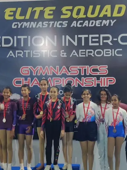 The girls' team with their parents on the podium. The support from families is a crucial part of our gymnasts' success.