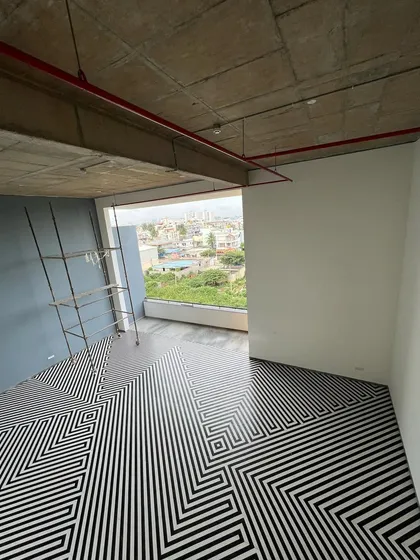 The floor of a social space in "The Treehouse" features a bold, graphic pattern. This area, with its view of the city, is designed to be a vibrant hub for residents.