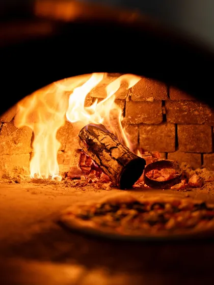 The heart of my pizzeria is the wood-fired oven. The dancing flames and intense heat are what give my pizzas their signature smoky flavor and perfectly blistered crust. It's the traditional Italian method that you can taste in every single bite.