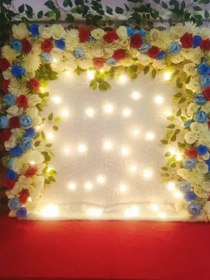 This floral frame uses a unique color combination of red, white, and blue artificial flowers. Paired with a backdrop of fairy lights, it creates a bright and sparkling effect that is both festive and different.